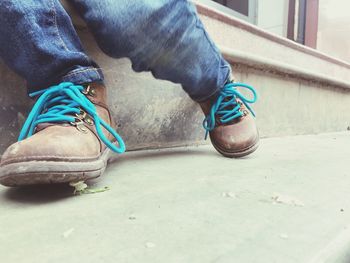 Low section of person wearing shoes sitting on floor