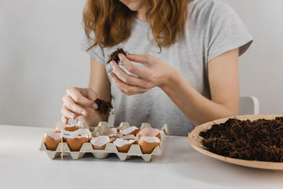 Midsection of woman holding ice cream on table