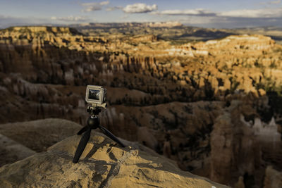 Close-up of camera on rock against canyon