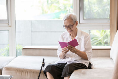 Young woman sitting by window at home