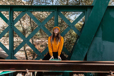 Portrait of woman standing on footbridge