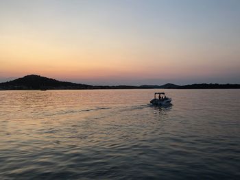 Silhouette boat in sea against sky during sunset