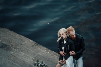 Couple kissing on water at shore