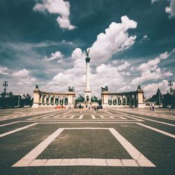 View of city street against cloudy sky