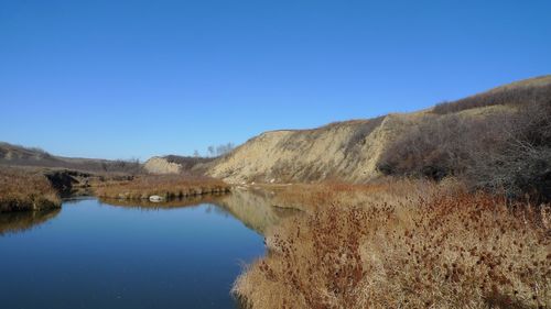 Scenic view of lake against clear blue sky