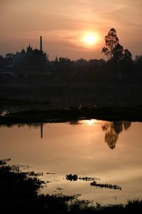 Scenic view of lake against orange sky