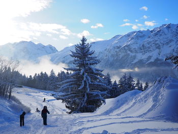 People walking on snow covered landscape