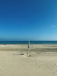 Scenic view of beach against clear blue sky