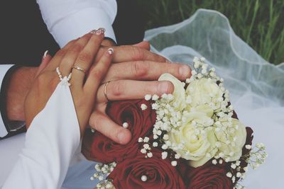 Mid section of a couple holding bouquet