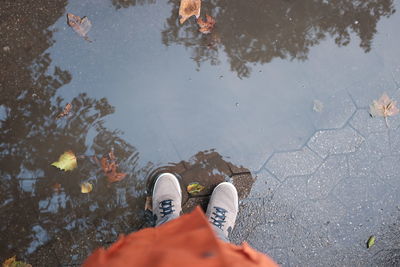 Low section of man standing in puddle