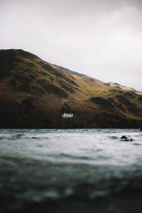 Scenic view of sea and mountains against sky