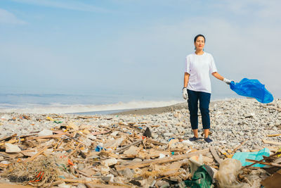 Young woman volunteer on a beach contaminated with toxic waste. copy space