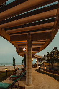 People relaxing on seat against clear sky