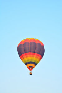 Low angle view of hot air balloon against clear blue sky