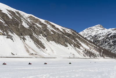 Scenic view of snowcapped mountains against clear blue sky