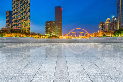 Illuminated modern buildings against sky in city