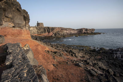 Round castle on the shore of one of the many lanzarote coast made from local, volcanic rocks.