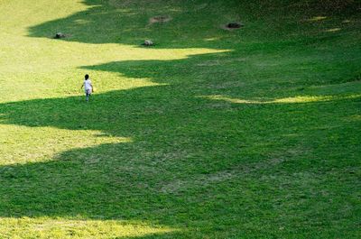 Shadow of people on grassy field