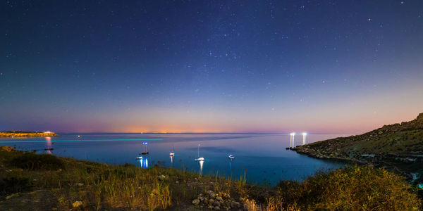 Scenic view of sea against clear sky at night