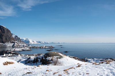 Scenic view of sea and snowcapped mountains against sky