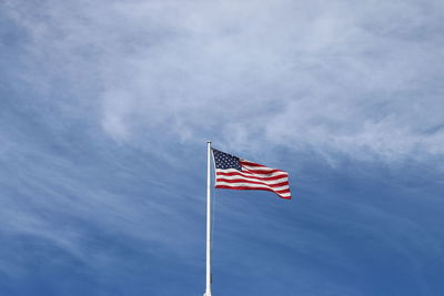 Low angle view of flag against cloudy sky