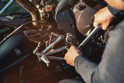 Midsection of man working on motorcycle