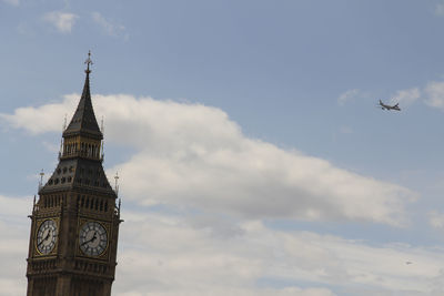 Low angle view of clock tower against cloudy sky