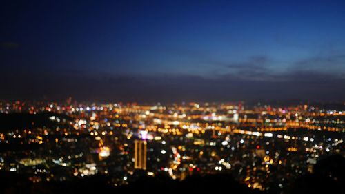 Illuminated cityscape against sky at night