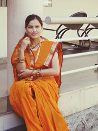 Portrait of a smiling young woman sitting in hostel 