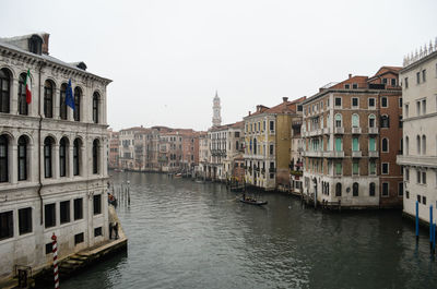 Canal amidst buildings against sky