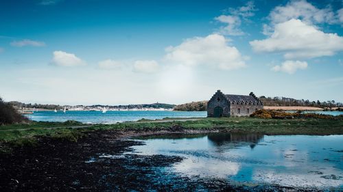 Buildings by sea against sky