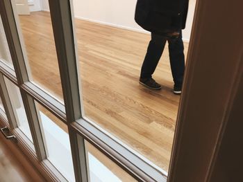 Low section of man standing on wooden floor