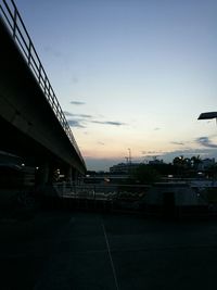 Bridge in city against sky during sunset