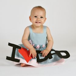 Portrait of happy baby girl with i love dad text over white background