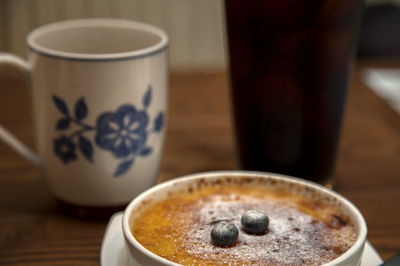 Close-up of drinks and creme brulee on table