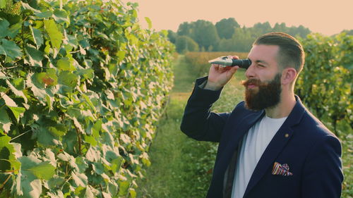 Hipster man looking through equipment at vineyard