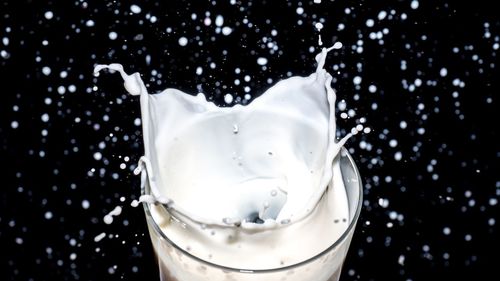 Close-up of water splashing in glass against black background