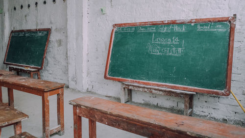 Empty chairs, table and blackboard in a classroom