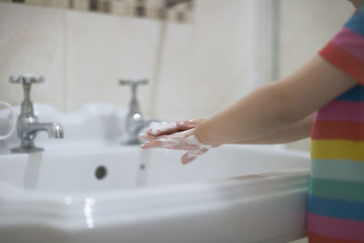 Young girl washing hand by herself at bathroom