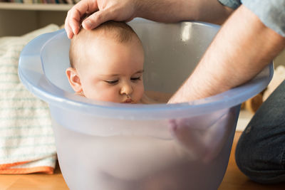 Father bathing son in bucket
