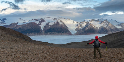 Man standing on snowcapped mountain against sky
