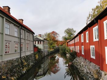 Houses and trees by buildings against sky