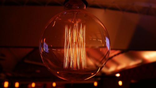 Close-up of illuminated light bulb on table