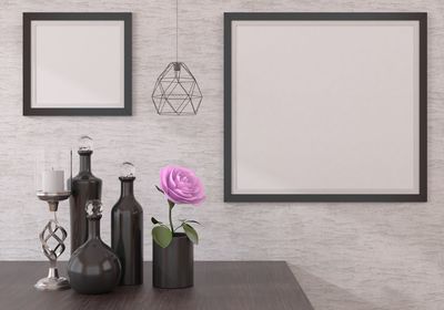 Flower vase on table against wall at home