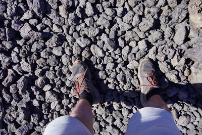 Low section of man standing on rock