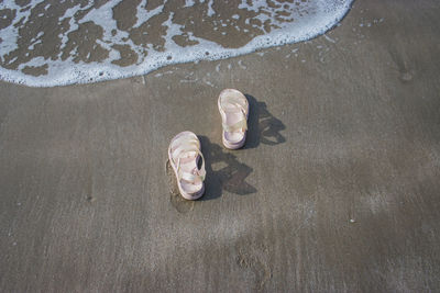 High angle view of man lying down on wet sand