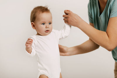 Midsection of mother and daughter against white background