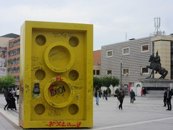 People on street in city against sky