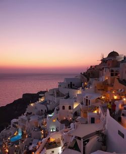 High angle view of buildings by sea against sky during sunset