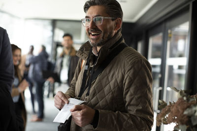 Happy businessman showing id card at conference center